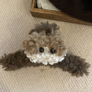 Close-up of a plush puppy dog hair claw clip with soft brown and beige faux fur texture