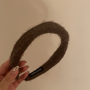 Vue détaillée de l'étiquette faite main à l'intérieur du serre-tête en peluche marron