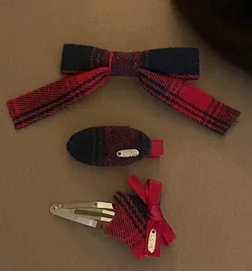 Detail of red plaid bow hair clips and star-shaped barrette set with Love engraving
