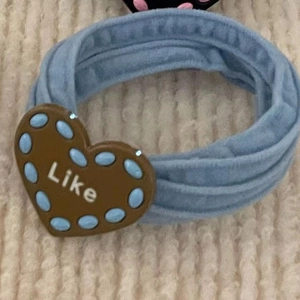 Light blue seamless hair scrunchie with brown heart charm featuring Like text and dots