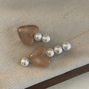 Detail der eleganten herzförmigen braunen Haarspange mit weißen Kunstperlen auf Metall