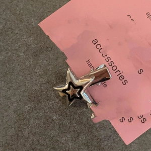 Barrette étoile argentée style Y2K avec détails noirs sur carton de présentation rose