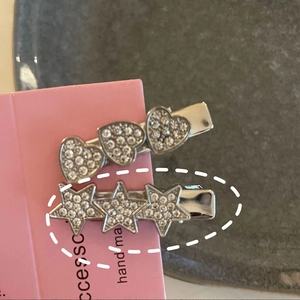 Vue macro de barrettes à strass étincelants en forme d'étoile et de cœur sur carte