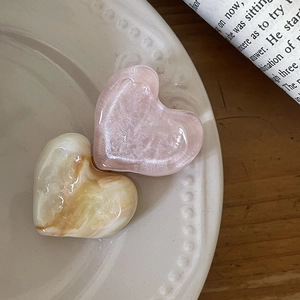 Detail view of heart-shaped marble and glitter hair clips on an aesthetic ceramic plate