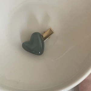 Minimalist heart-shaped hair clip with blue resin finish and golden metal base