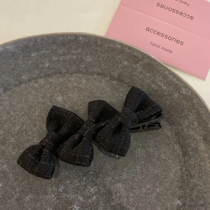 Detailed view of tweed bow hair clips with silver threads and black metal duckbill clip