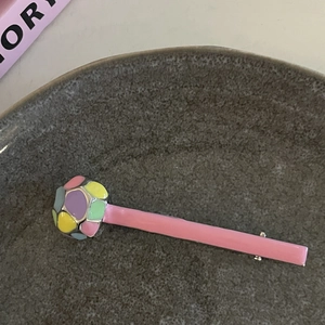 Detailansicht der rosa und blauen Haarklammer auf einer strukturierten Keramikplatte