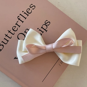 French style ivory and pink double layer ribbon bow hair clip on a pink book