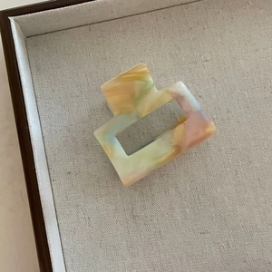 Détail d'une pince à cheveux carrée évidée avec texture marbrée en acétate