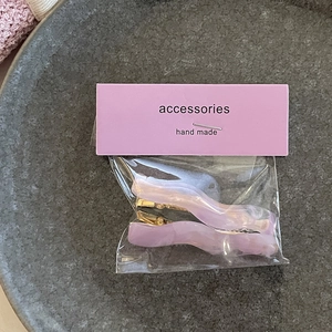 Set of 2 wavy marble acetate hair clips in purple and pink with gold metal fasteners