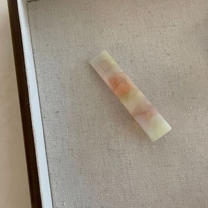 Vue détaillée d'une longue pince à cheveux en acétate avec texture marbrée pastel