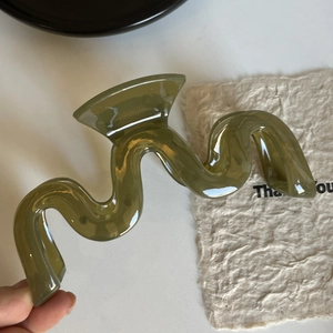Détail de la grande pince à cheveux vague en résine vert olive translucide