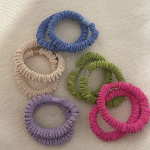 Detail showing colorful pleated fabric hair ties with texture and plastic connectors