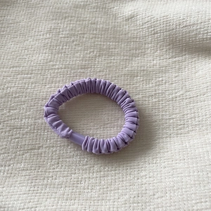 Chic purple pleated fabric scrunchie with elastic texture for ponytail hairstyles