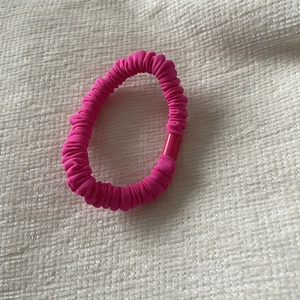 Detailed macro view of the hot pink pleated fabric scrunchie with a matching plastic buckle