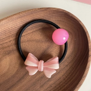 Elastico per capelli con fiocco rosa e perla lucida su vassoio in legno per ragazze