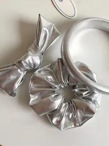 Three-piece silver metallic hair accessory set including bow clip, scrunchie and headband