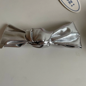 Silver bow hair clip with metallic finish and pearlescent coating for women
