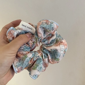 Chouchou floral fait main en tissu bleu et rose avec bordure passepoilée bleue