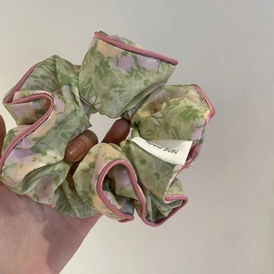 Chouchou fleuri fait main en tissu vert clair avec fleurs mauves et bords en soie rose