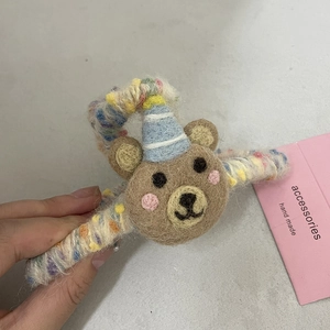 Handmade brown wool felt bear hair claw clip with blue party hat and colorful yarn wrap