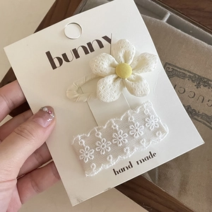 Detail view of handmade white lace barrette and fabric flower clip set on card