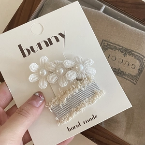 Detail of handmade lace flower hair clips with faux pearls on display card