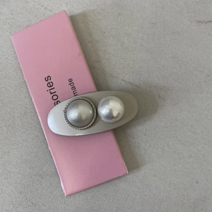 Detailed macro of a Korean silver hair clip with elegant faux pearls and sparkling rhinestones