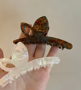 Détail de pinces à cheveux papillon en acétate avec finitions marbrées et nacrées