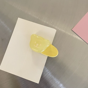 Detailansicht der gelben Bären-Haarspange aus Harz auf einer weißen Displaykarte