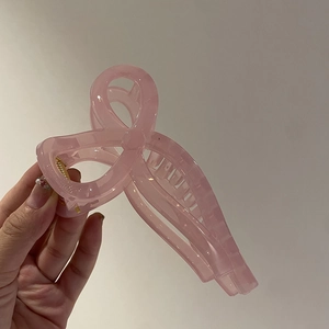 Pink translucent bow hair claw clip made of resin with metallic spring for women