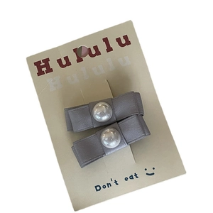 Set di due fermagli per capelli con fiocchi di raso grigio e perle su carta espositiva