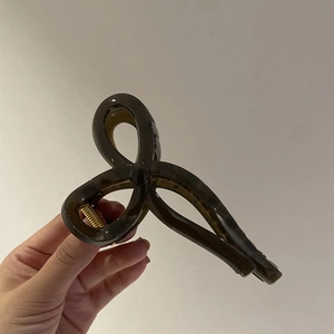 Elegant large amber resin bow claw clip for women featuring a durable metal spring