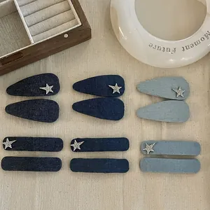 Close-up of denim star hair clips in blue shades with rhinestone details on a table