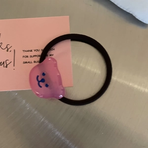 Nahaufnahme eines rosa Bären-Haargummis aus Harz mit elastischem schwarzem Band