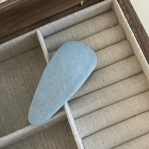 Light blue denim fabric star-shaped hair clip for women in a jewelry box setting