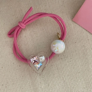 Sweet pink elastic hair tie featuring a pearlescent bead and crystal heart pendant