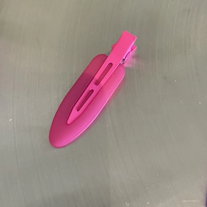 Close-up of matte rose red duckbill hair clip with streamlined hollow design and metal spring