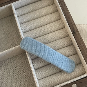 Detail of blue denim fabric star hair clip with glittering texture in a wooden box