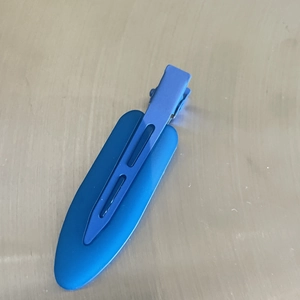 Detailed view of matte blue two-tone seamless hair clip on a metallic grey background