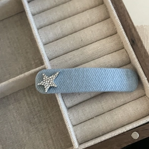 Detail of light blue denim fabric hair clip with a sparkling rhinestone star ornament