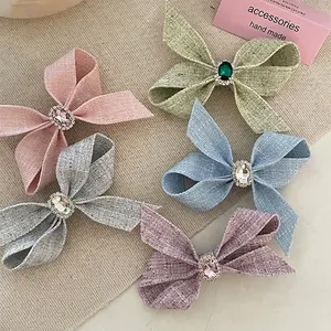 Set di fermagli a fiocco in tweed con pietre di cristallo pastello su tessuto beige