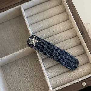 Detail of dark blue denim star hair clip with rhinestones in a wooden jewelry box