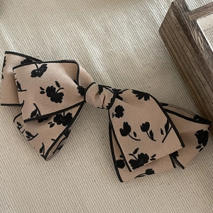 Elegant floral bow hair clip in beige and black vintage print with high texture