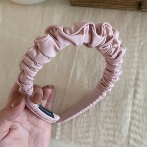 Elegant pink pleated cloud headband with handmade label and glossy fabric finish