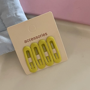 Detail view of 4-piece matte oval BB hair clips set in lemon green and mustard yellow