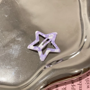 Barrette en forme d'étoile avec motif à carreaux violets et blancs sur un plateau