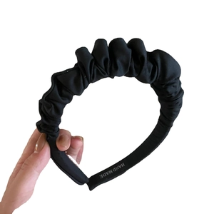 Elegant handmade black pleated fabric headband featuring a stylish ruffled scrunchie design