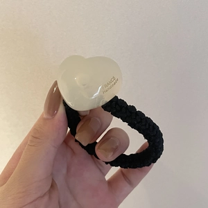 Elastic braided hair tie with white heart charm and FRANCE Handmade text on wrist