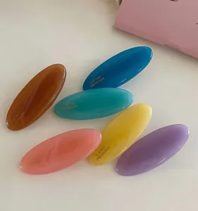 Detailed view of oval candy-colored acrylic hair clips in a six-color pastel assortment